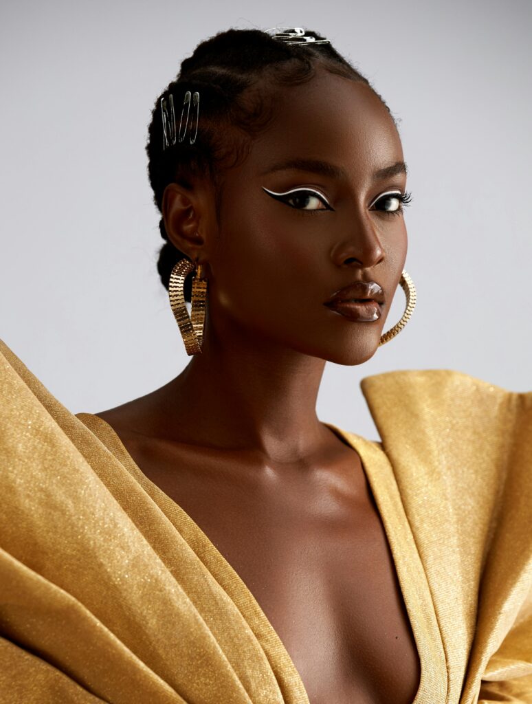 Stunning portrait of a woman in a glamorous gold dress, showcasing elegance and style.